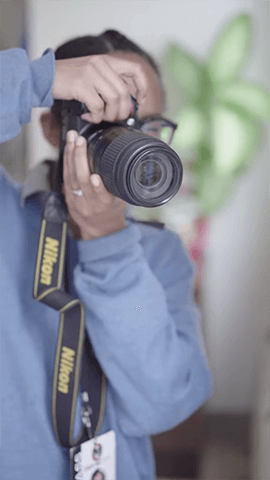 Tianna Manon holding a camera to take a picture.