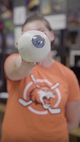 Lily Lautenschlager holding a model eyeball.