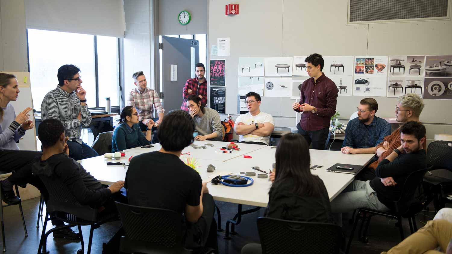 Large group of people sitting around a table talking.